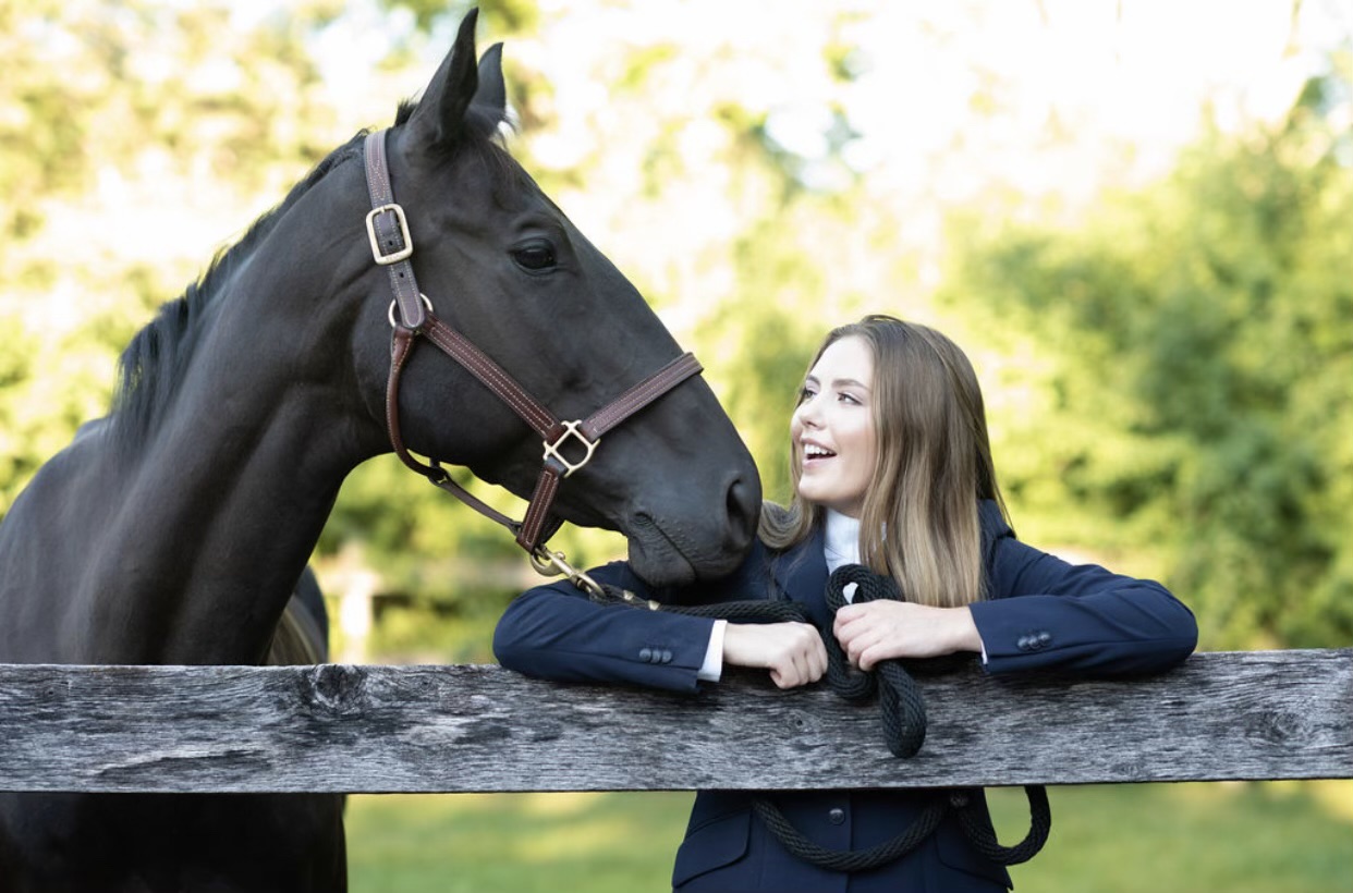Seventh Farm: Rachel smiling at a black horse by the fence